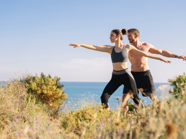 couple-doing-balance-exercise-beach_23-2147642549