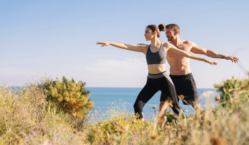 couple-doing-balance-exercise-beach_23-2147642549