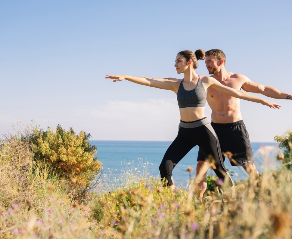 couple-doing-balance-exercise-beach_23-2147642549