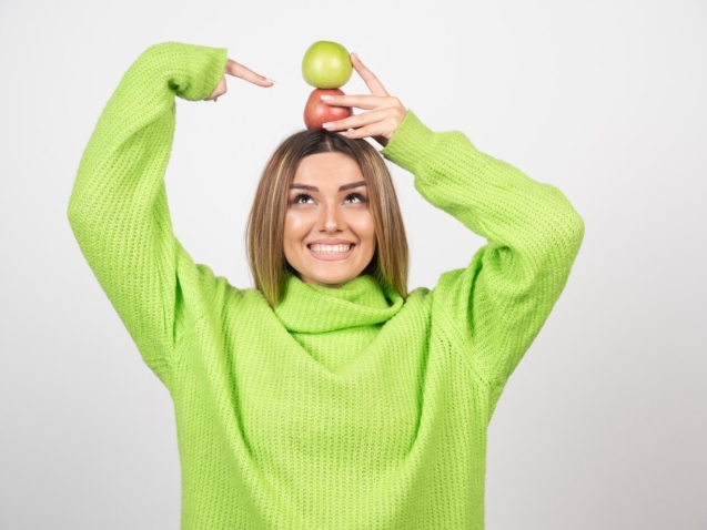 young-woman-green-t-shirt-holding-two-apples-overhead_114579-27409