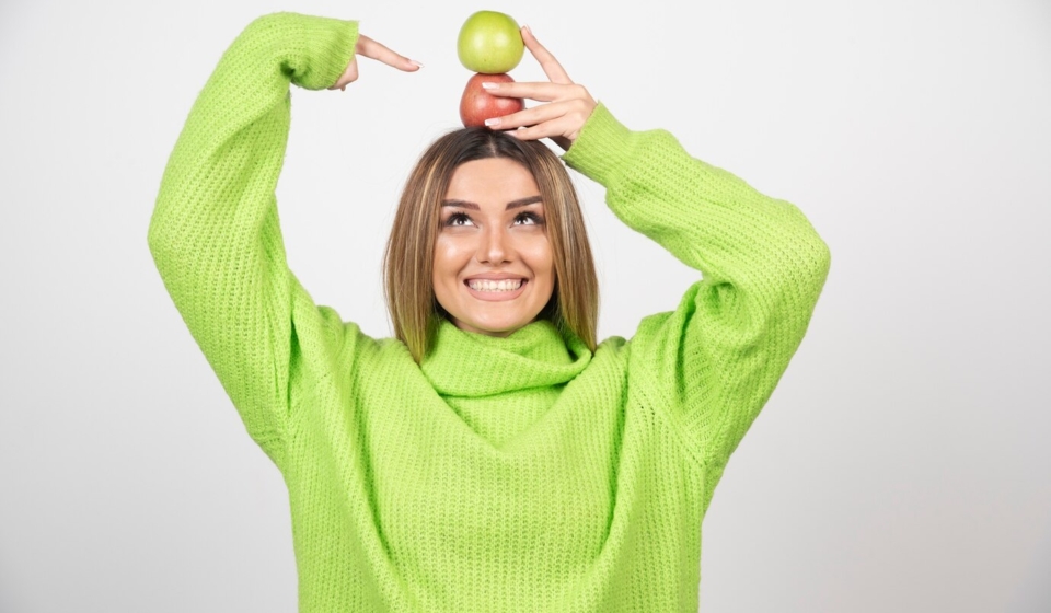 young-woman-green-t-shirt-holding-two-apples-overhead_114579-27409