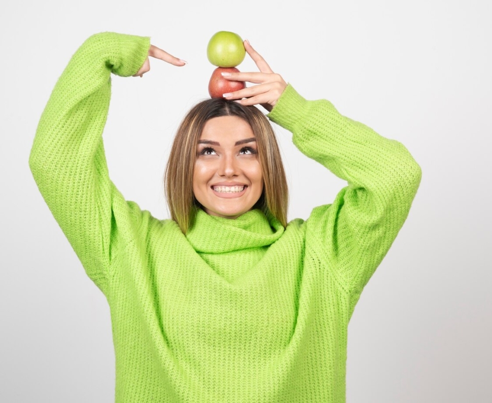 young-woman-green-t-shirt-holding-two-apples-overhead_114579-27409